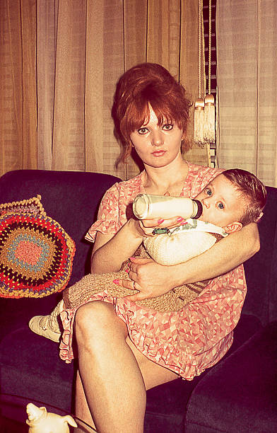 retro joven madre con su hijo lindo de lactancia - milk bottle fotos fotografías e imágenes de stock