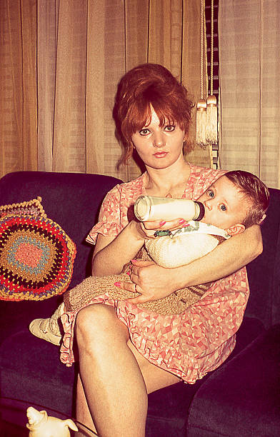 Retro young mother feeding her cute son stock photo