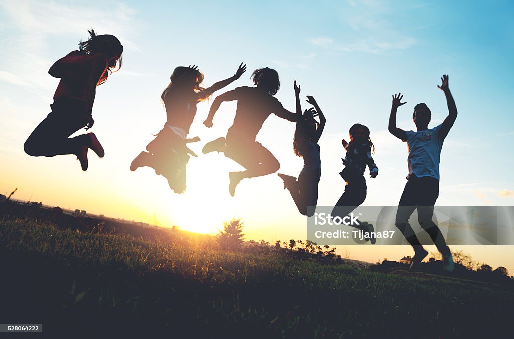 Group of people jumping outdoors; sunset Group of people jumping outdoors; sunset  Teenager Stock Photo