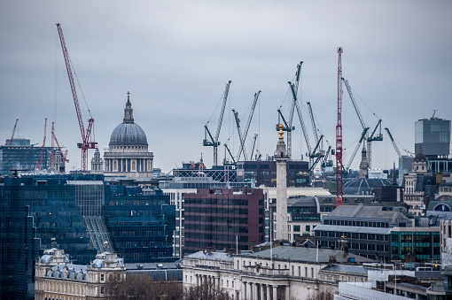 St Paul's Cathedral, Monument and construction cranes in London seen from Tower Bridge on a cloudy day. 
