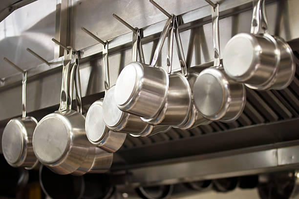 Many pans hanging in a restaurant kitchen Many pans hanging in a restaurant kitchen indoors restaurant hotel work tool stock pictures, royalty-free photos & images