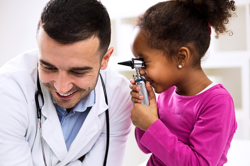 Doctor otologist palying with his patient using otoscope