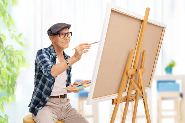 istock Elderly man drawing on a canvas at home 528067346