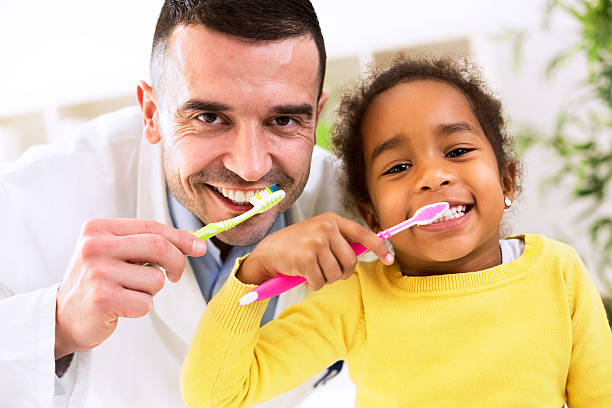istock Pediatrician learn cute african girl brushing tooth 528067436