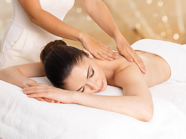 woman having massage of body in spa salon - massage stockfoto's en -beelden