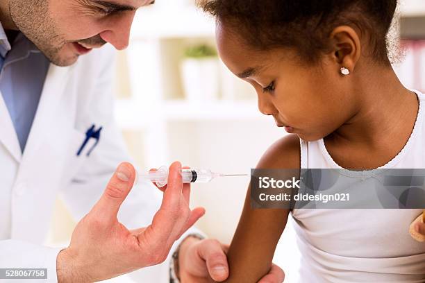 Doctor Injecting Vaccine To Cute African Girl Stock Photo - Download Image Now - Vaccination, Child, Sewing Needle