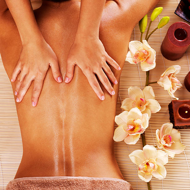 masseur mulher fazendo massagem nas costas no salão spa - pampering massaging indoors adult - fotografias e filmes do acervo