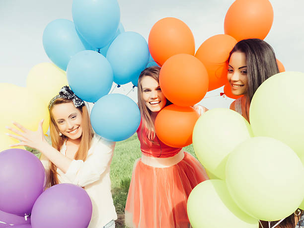 istock Young people holding a bunch of balloons 528069998