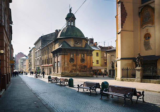 Pedestrian Walkway in Old City of Lviv, Ukraine Lviv is a historical city with medieval buildings. The building on the right (with the statue) is a 14th-century Roman Catholic cathedral named "Latin Cathedral". It is located in the city's Old Town, in the south western corner of the market square, called Cathedral Square. circa 14th century photos stock pictures, royalty-free photos & images