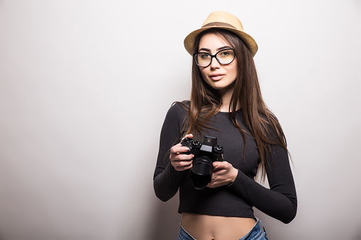 Cute tourist girl with photo camera on a white background