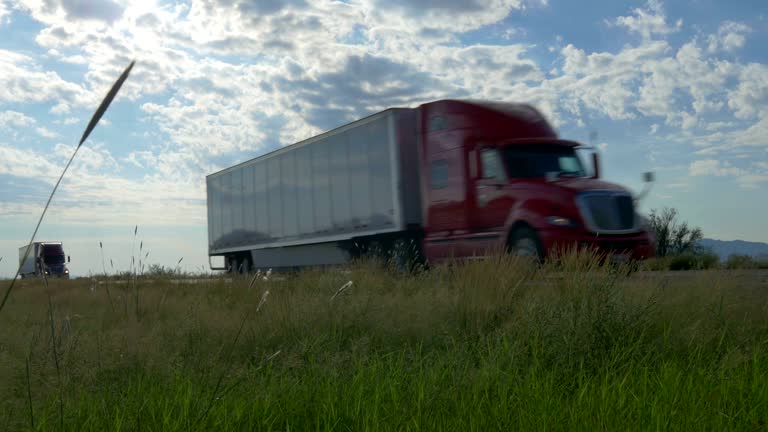 Big freight semi trucks speeding and passing by on highway across the country