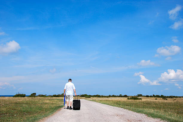 istock Man walking away at a gravel road 528102533