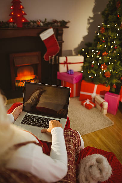 istock Santa sitting and typing on laptop 528102747