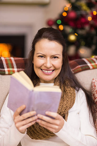 istock Smiling brunette reading on the couch 528103355