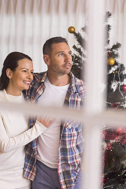 istock Smiling couple hugging near the christmas tree 528104151
