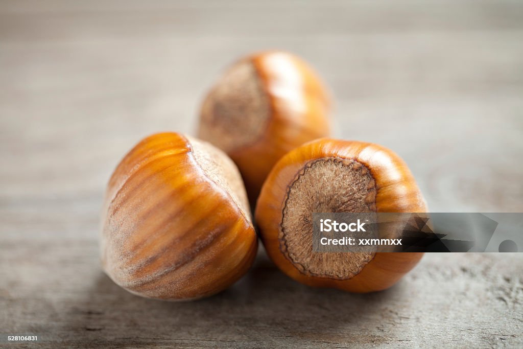 Hazelnuts close up Close up of hazelnuts on old wooden table. This file is cleaned and retouched. Autumn Stock Photo