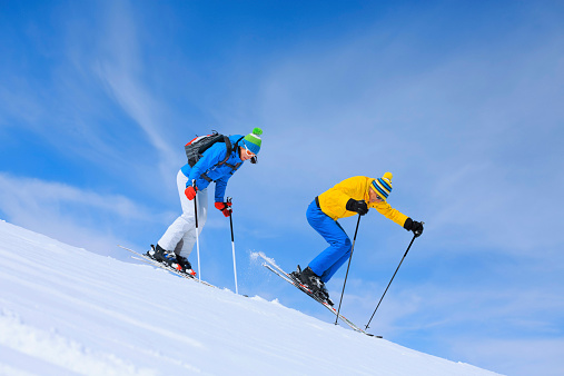 Men and women snow skiers off piste skiing powder snow