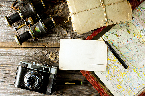 letter from travel concept - old map holder, camera and binoculars