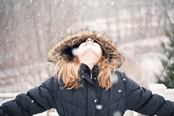istock Young Girl Looking Up At Snow Falling 528133789
