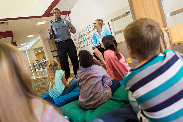 Police or school security officer speaking to young students