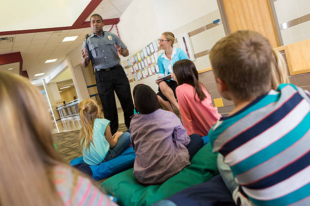 Police or school security officer speaking to young students Police or school security officer speaking to young students. safe guard stock pictures, royalty-free photos & images