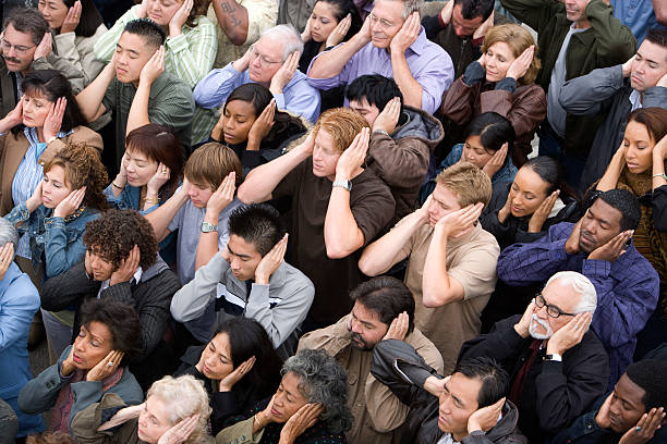 multitud de personas - hand to ear fotografías e imágenes de stock