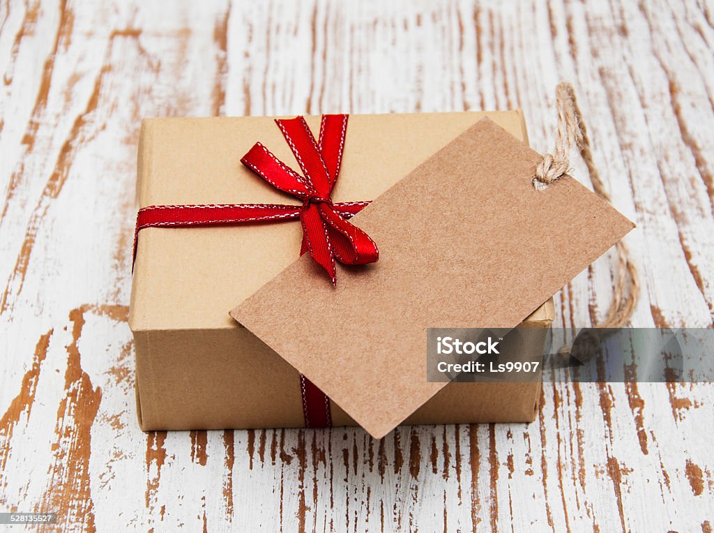 vintage gift box package with blank  tag vintage gift box package with blank  tag on old wooden background Box - Container Stock Photo