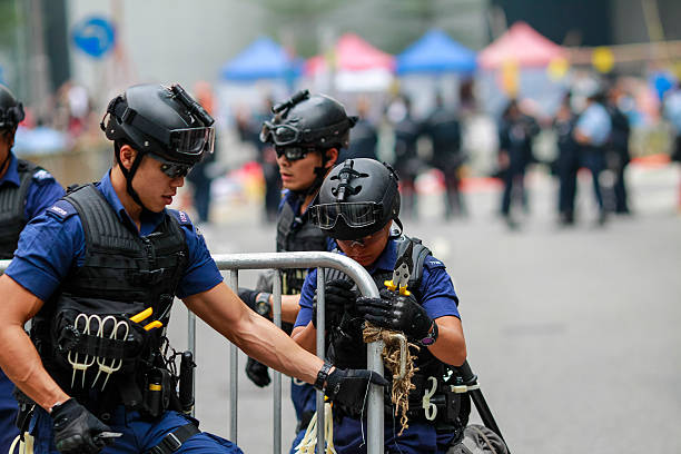 Hong Kong, Сhina - December 11, 2014: Workers and police remove barricades at an area blocked by pro-democracy protesters near the PLA headquarters in Hong Kong, December 11, 2014. Hong Kong authorities started on Thursday clearing the main pro-democracy protest site that has choked roads into the city's most economically and politically important district for more than two months as part of a campaign to demand free elections.