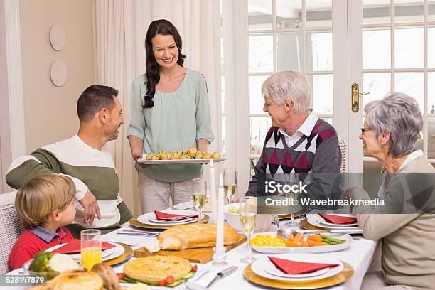 Woman Serving Christmas Dinner To Her Family Stock Photo - Download Image Now - 30-39 Years, 35-39 Years, 4-5 Years