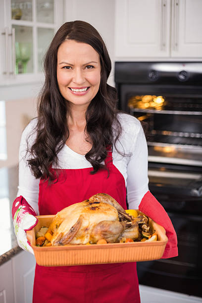 istock Happy brunette holding her roast turkey 528148159