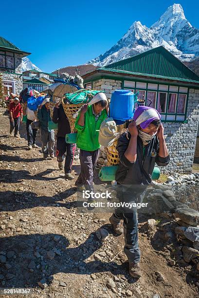 Line Of Sherpa Porters Carrying Expedition Kit Himalaya Mountains Nepal Stock Photo - Download Image Now