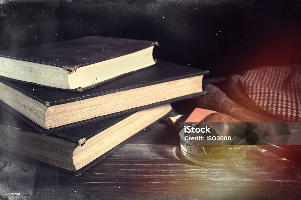 Retro style composition Vintage books and tobacco pipe on table. Edited image with vintage effect and scratches Addict Stock Photo