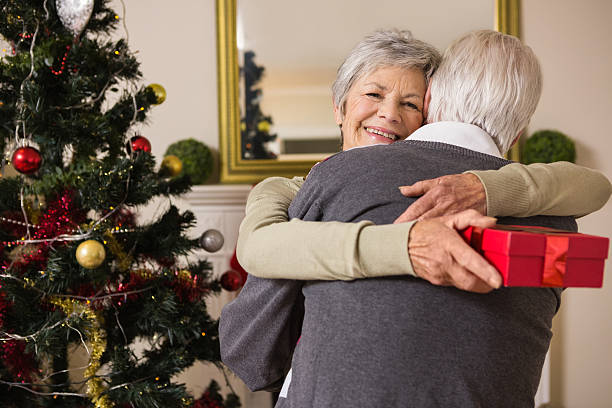 istock Senior couple hugging beside their christmas tree 528151363