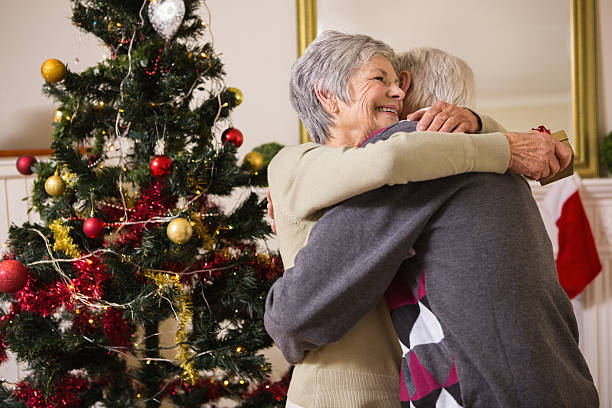 istock Senior couple hugging beside their christmas tree 528151373