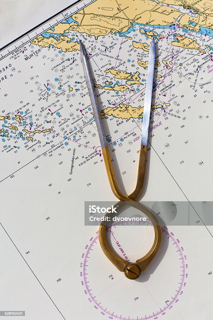 Pair of compasses for navigation on a sea map Pair of compasses for navigation on a sea map. Vertical shot Angle Stock Photo