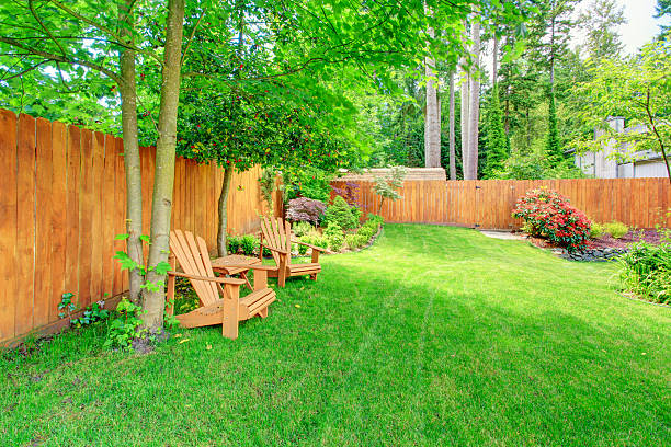 istock Fenced backyard with green lawn and sitting area 528162625