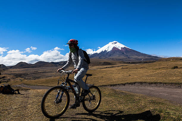 Cyclist and Cotopaxi volcano Cyclist in Cotopaxi National Park, about to start a morning walk along the slopes of the Cotopaxi volcano cotopaxi photos stock pictures, royalty-free photos & images