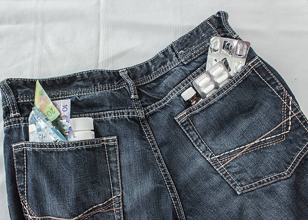 pílulas e dinheiro preso no bolso de trás de um jeans - twenty dollar bill currency five dollar bill number 20 imagens e fotografias de stock