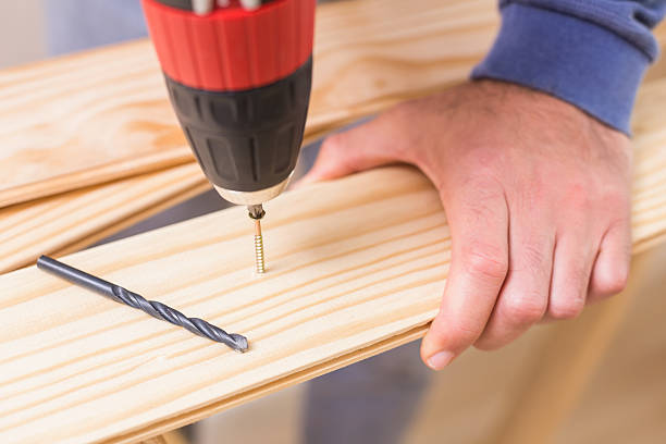 istock Casual man drilling hole in plank 528164991