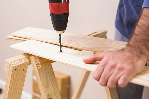 istock Casual man drilling hole in plank 528164997