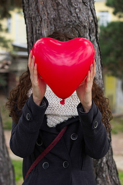 istock Girl behind the balloon heart 528165467