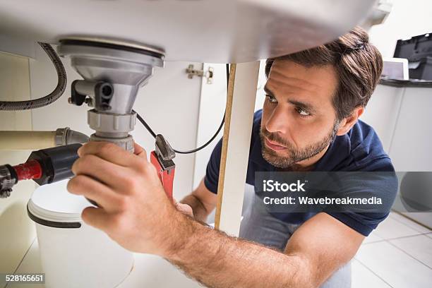 Plumber Fixing Under The Sink Stock Photo - Download Image Now - 30-39 Years, 35-39 Years, Adult