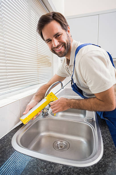 istock Plumber putting filling in between tiles 528165855