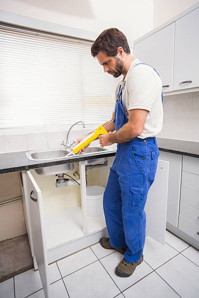 istock Plumber putting filling in between tiles 528165857