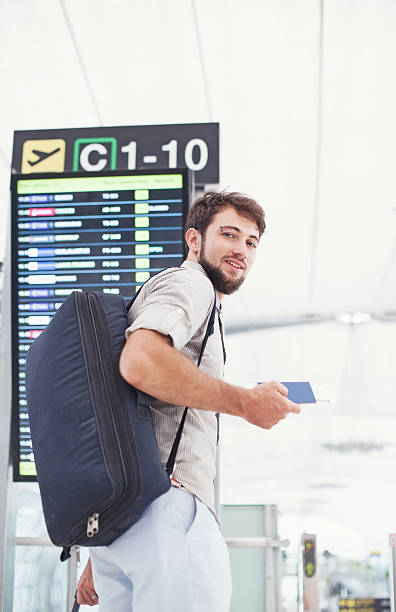 uomo con la valigia imbarcarsi in un aeroporto - bus rear view white commercial airplane foto e immagini stock