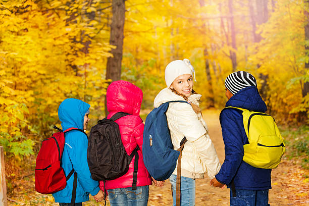 istock Back view of schoolchildren holding hands in row 528183345