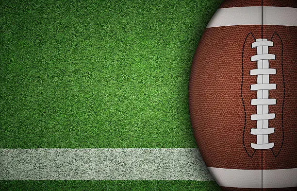 American football ball on green grass and white line. with lots of copy space.