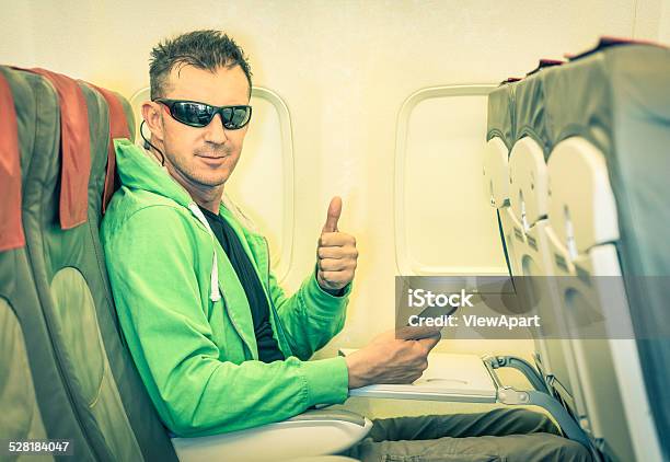 Young Hipster Hombre Pasajeros Satisfecho Pulgares Arriba En El Interior De Un Avión Foto de stock y más banco de imágenes de Avión