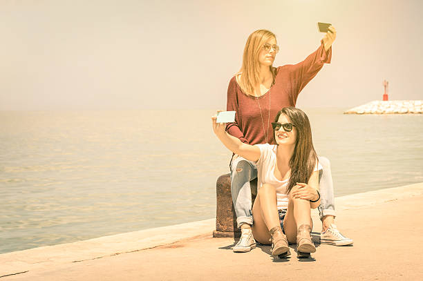 Hipster girlfriends best friends taking double selfie at wharf docks