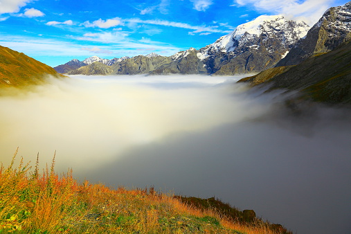 Winter morning in mountains. Pink sunlight at snowy mountain hills. Winter frosty sunrise landscape with clear sky.